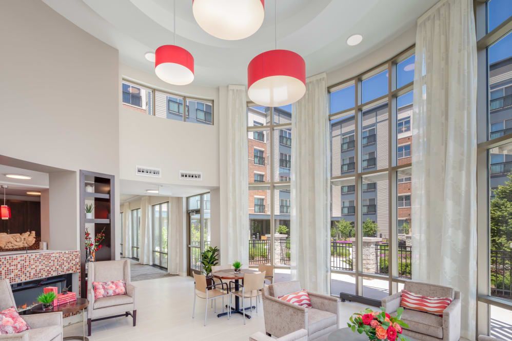 A modern lobby area with large windows, stylish furniture, and bright lighting.