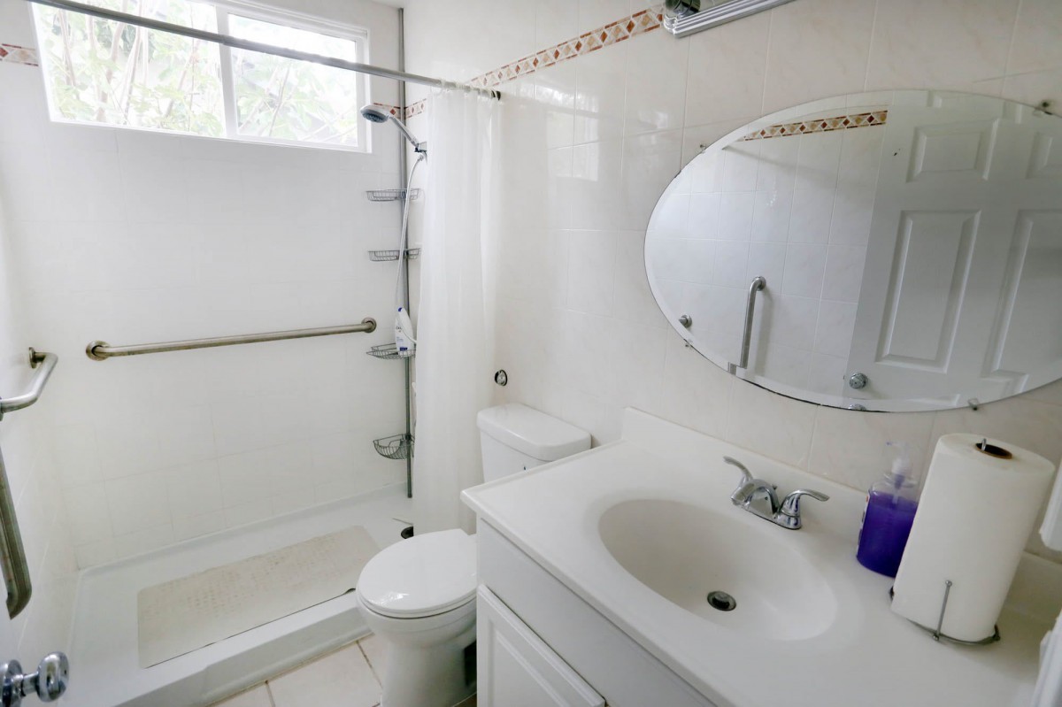 A clean and modern bathroom with a shower, sink, and toilet.