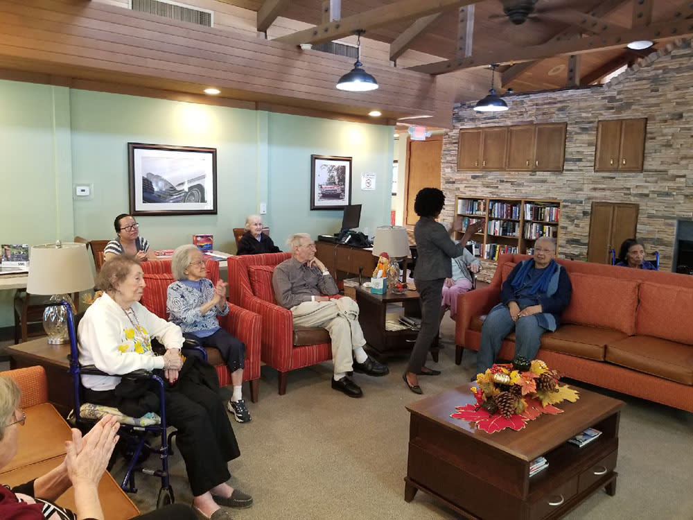 A group of elderly people gathered in a cozy living room for a social event.