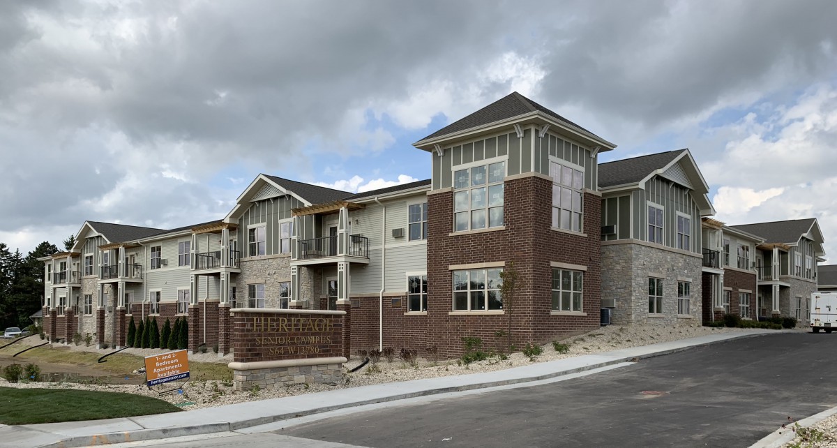 A modern residential building with a brick exterior under a cloudy sky.