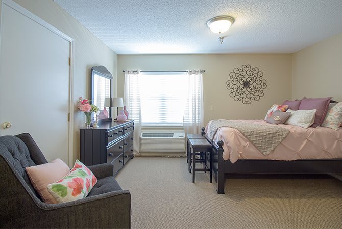 A cozy bedroom with a neatly made bed and stylish decor.