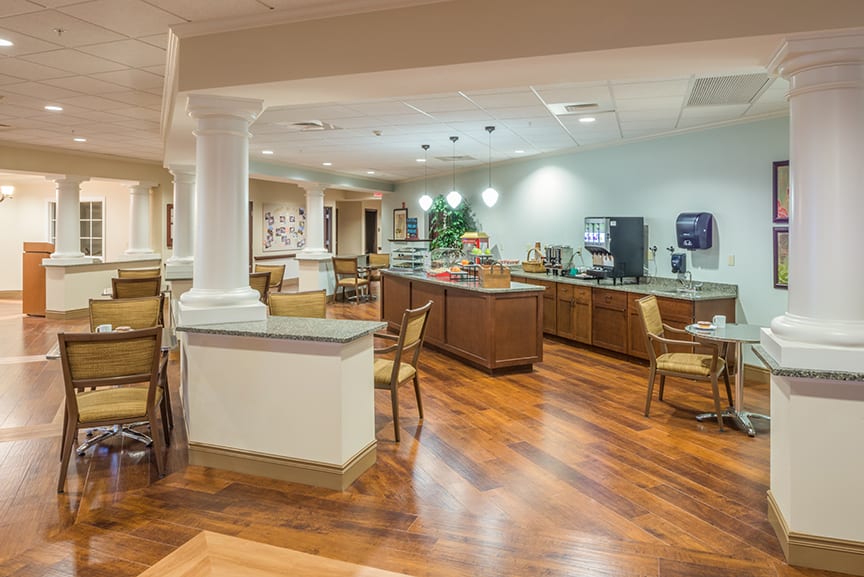 A modern cafe interior with wooden floors and seating area.