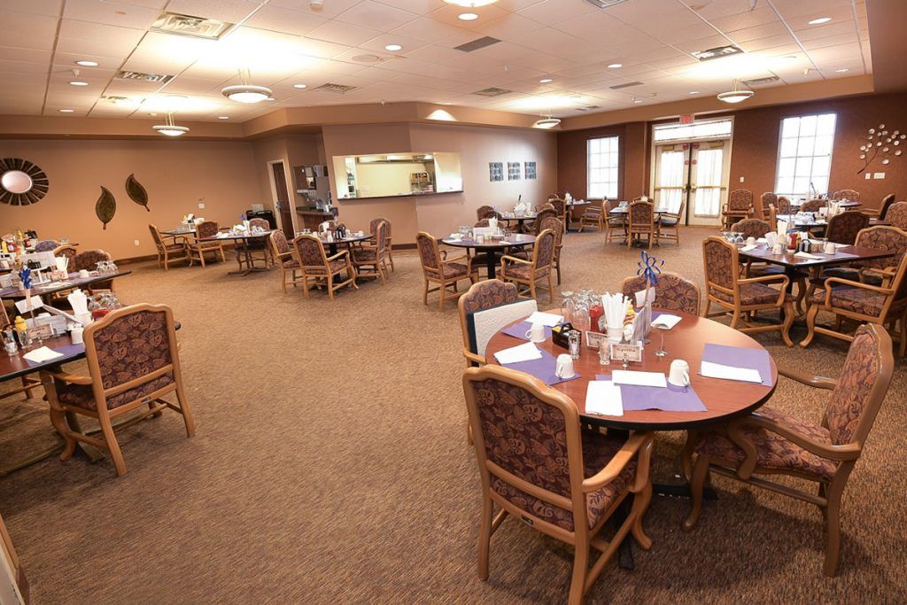 A cozy dining area with neatly arranged tables and chairs, well-lit for a welcoming atmosphere.