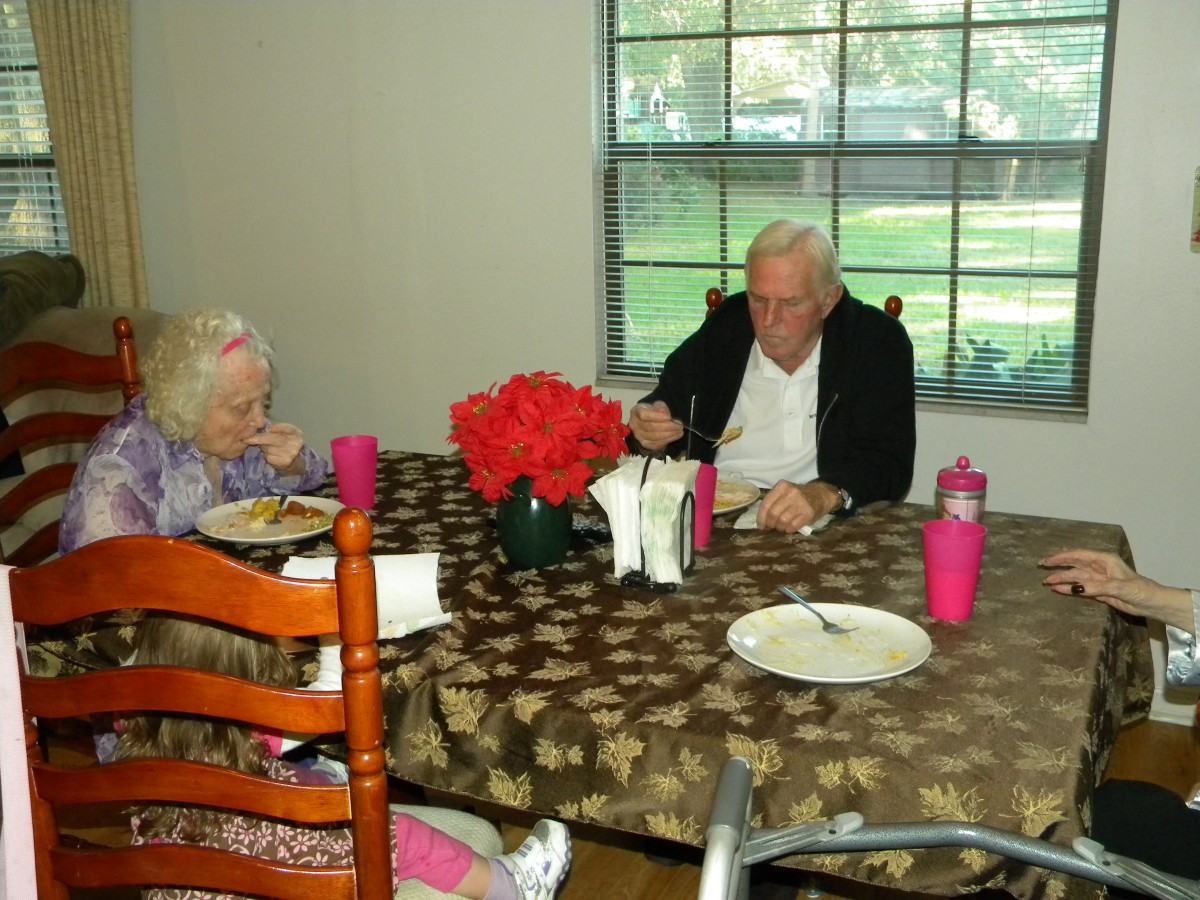 An elderly couple having a meal together at a dining table.