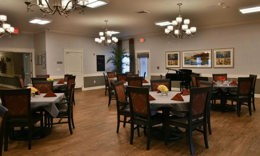 Elegant dining area with neatly arranged tables and chandeliers.