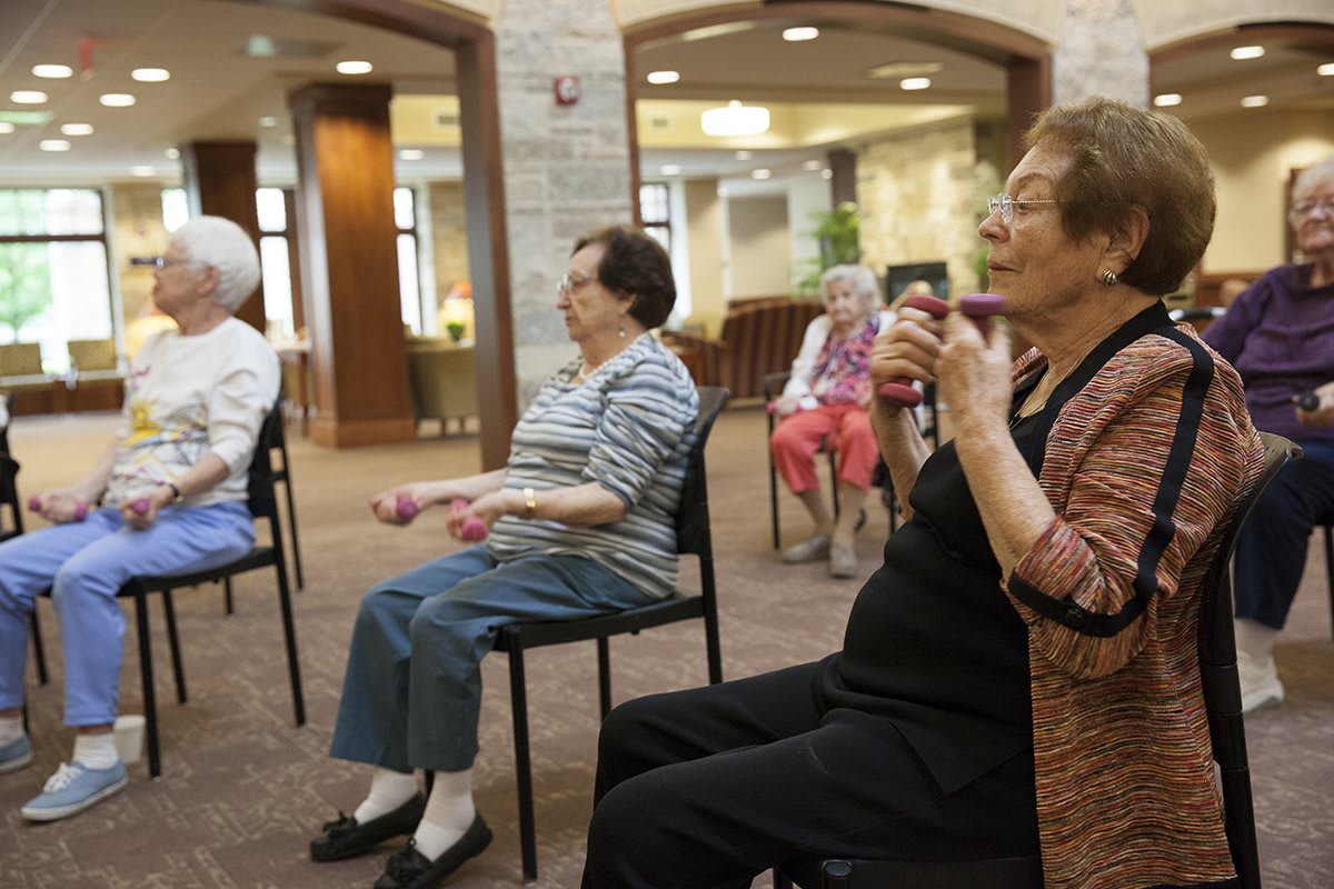 A group of seniors participating in a seated exercise session at a community center.