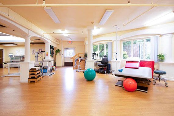 A spacious gym with exercise equipment and yoga balls.