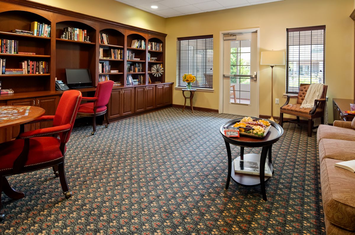 A cozy office space with bookshelves, desks, and comfortable seating.