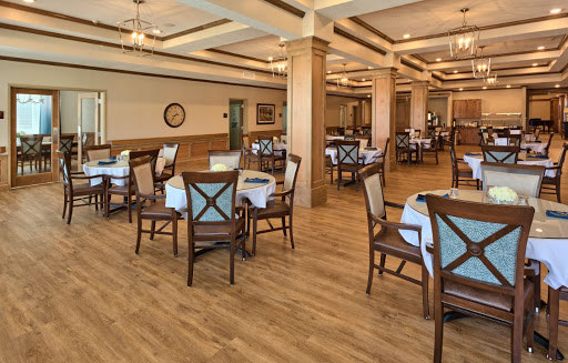 A spacious and elegantly designed dining area with wooden furniture and a warm ambiance.