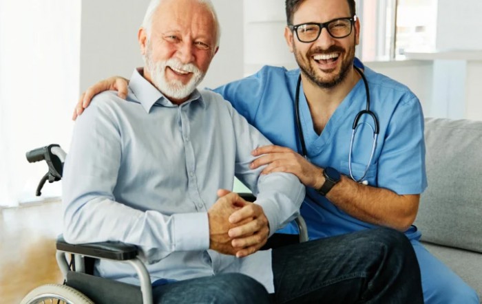 A smiling doctor with an elderly patient in a wheelchair.
