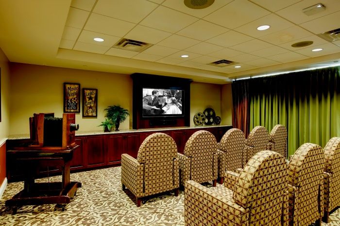 A luxurious home theater room with patterned seating and a large screen.