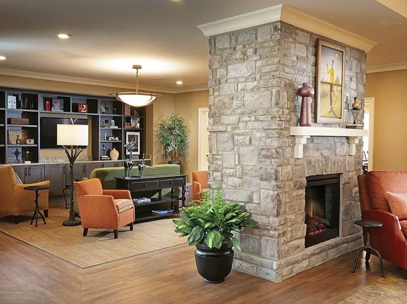 A cozy living room with a stone fireplace and comfortable seating area.