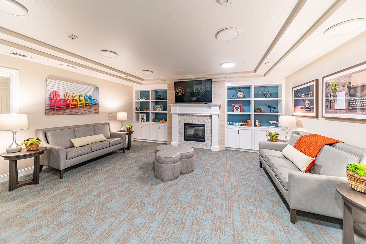 A modern living room featuring two sofas, a central fireplace, and built-in bookshelves adorned with decorative items.