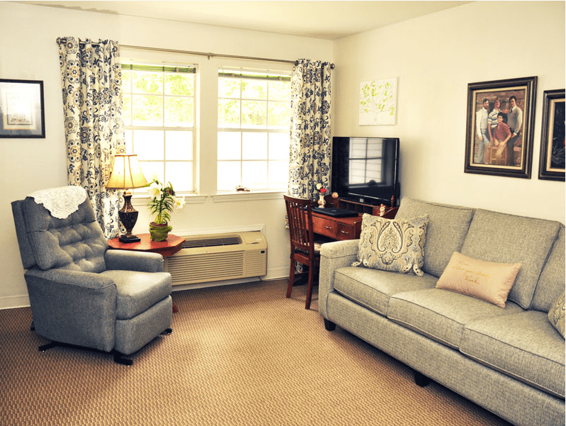 Cozy living room with a sofa, armchair, and television.