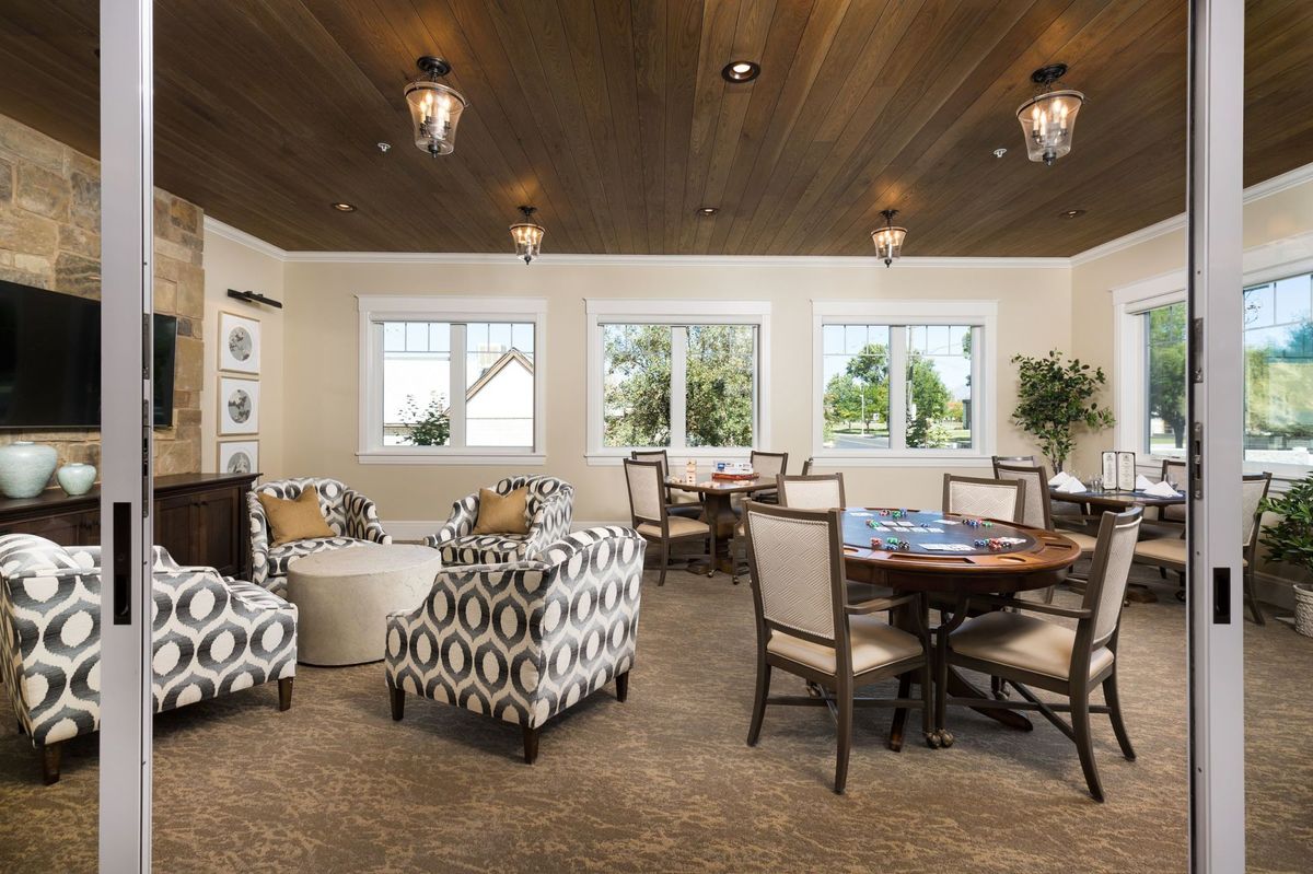 A cozy living room with patterned armchairs, tables, and decorative lighting.