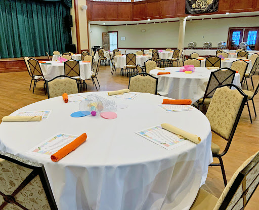 A spacious event venue set up with elegantly arranged tables and chairs, ready for a gathering.