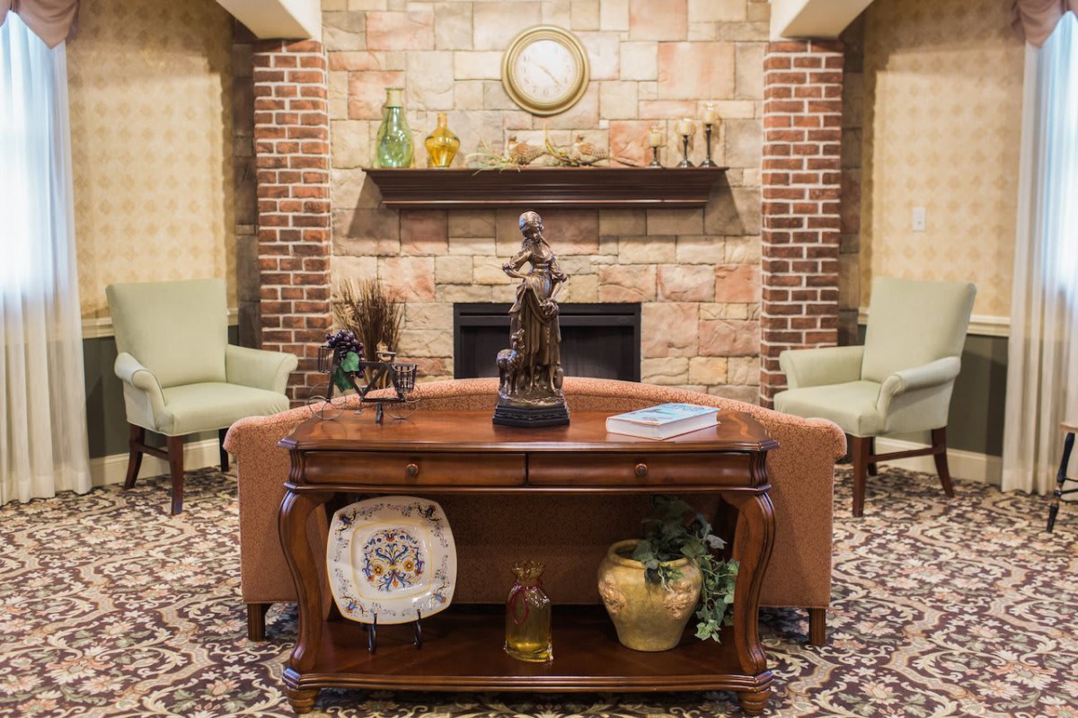A cozy living room with a brick fireplace, elegant decor, and comfortable seating.