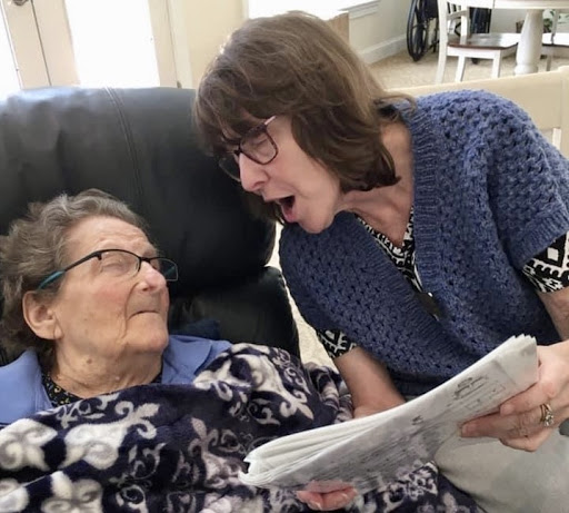 A heartfelt moment shared between a caregiver and an elderly woman, highlighting the importance of connection and companionship.