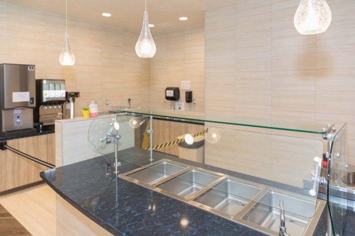 Modern kitchen with clean countertop and multiple sinks.