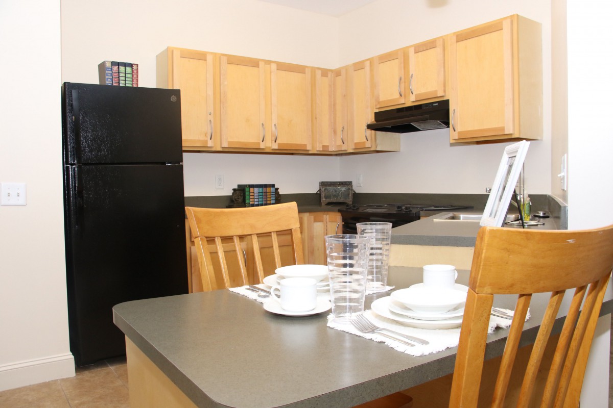 A cozy kitchen with wooden cabinets and a dining table set for a meal.