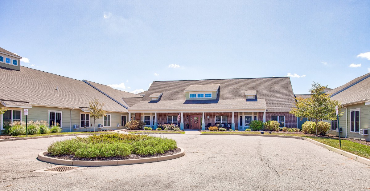 A suburban residential building with a landscaped driveway on a clear day.