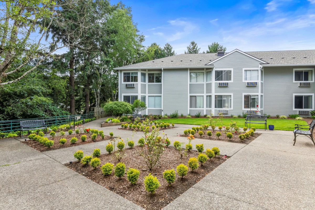 A well-maintained apartment building with landscaped gardens and pathways.