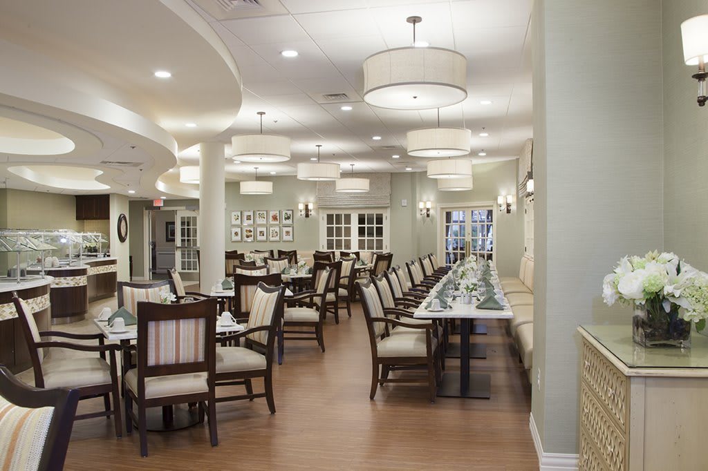 A well-lit dining room with neatly arranged tables and chairs.
