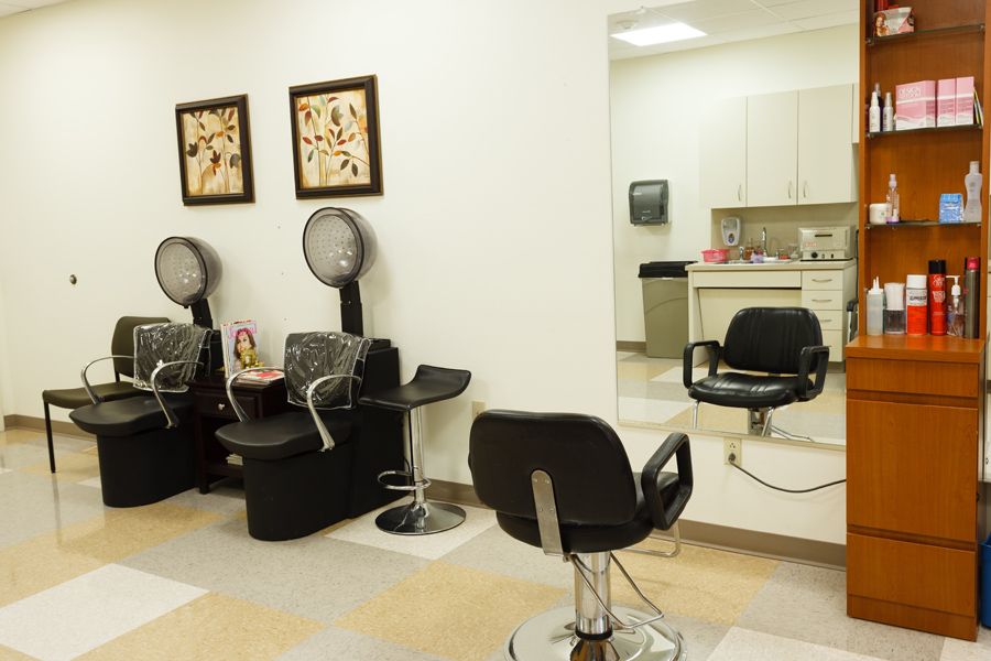 A tidy beauty salon interior with styling chairs and hair dryers.