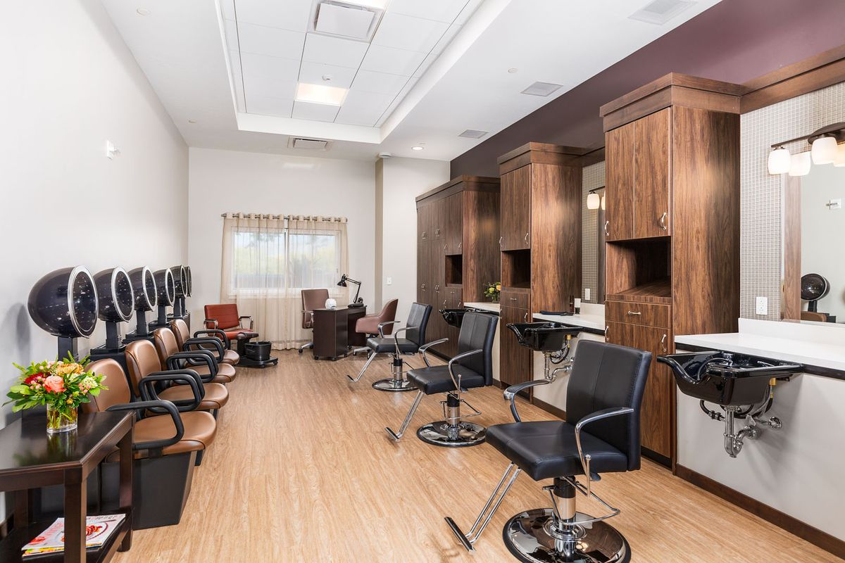 Interior view of a modern barber shop with chairs and mirrors.