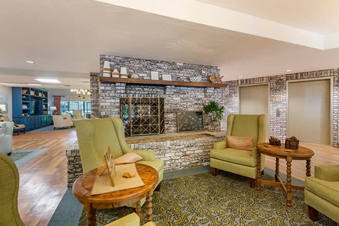 A cozy seating area featuring armchairs and a brick wall with decorative elements.