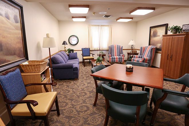 A cozy living room with sofas, chairs, and a dining table.