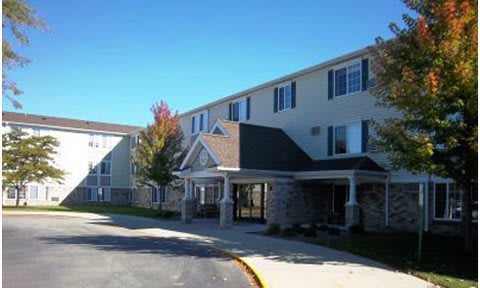 A residential building with a covered entrance and clear blue sky.