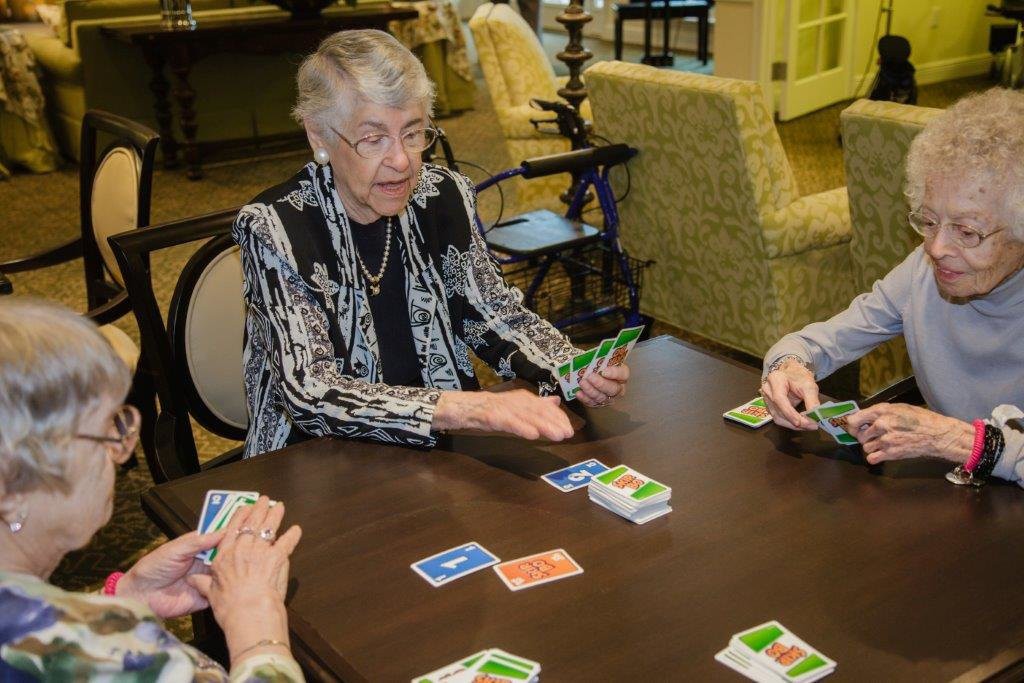 A group of seniors enjoying a card game together indoors.
