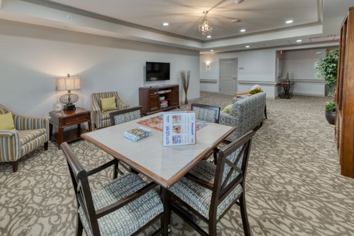 A cozy living room with a table, chairs, and a television set.