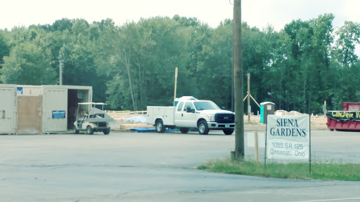 A work site featuring a pickup truck and construction equipment in a rural setting.