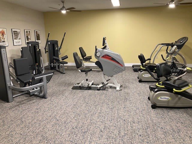 A well-equipped home gym with various exercise machines, including stationary bikes and other fitness equipment.