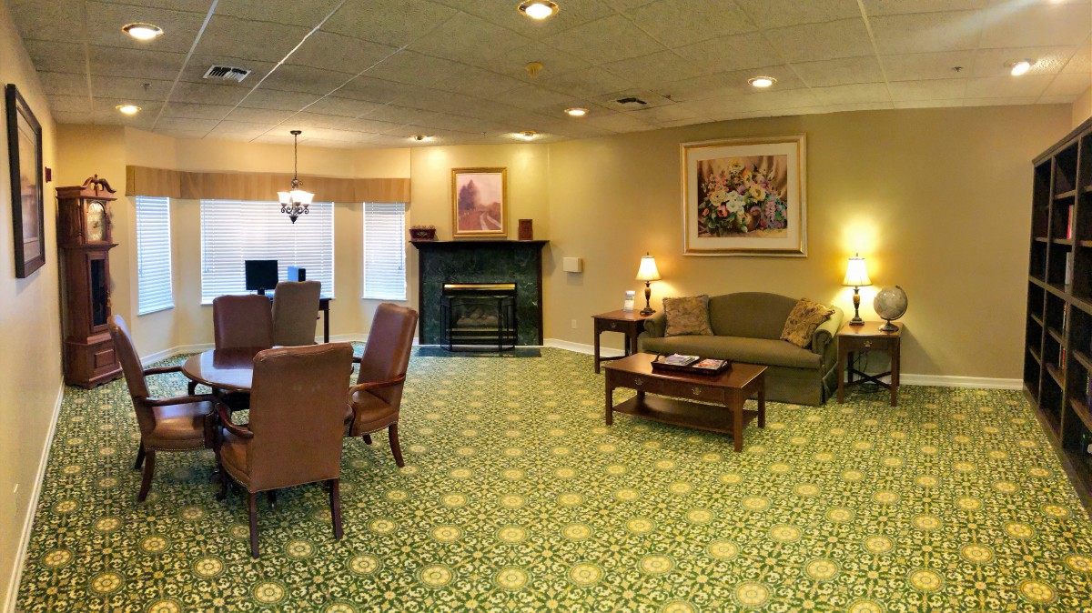 A cozy living room with a fireplace, comfortable seating, and decorative artwork.
