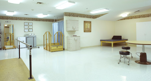 A spacious and well-lit rehabilitation room equipped with a ramp and minimal furnishings.