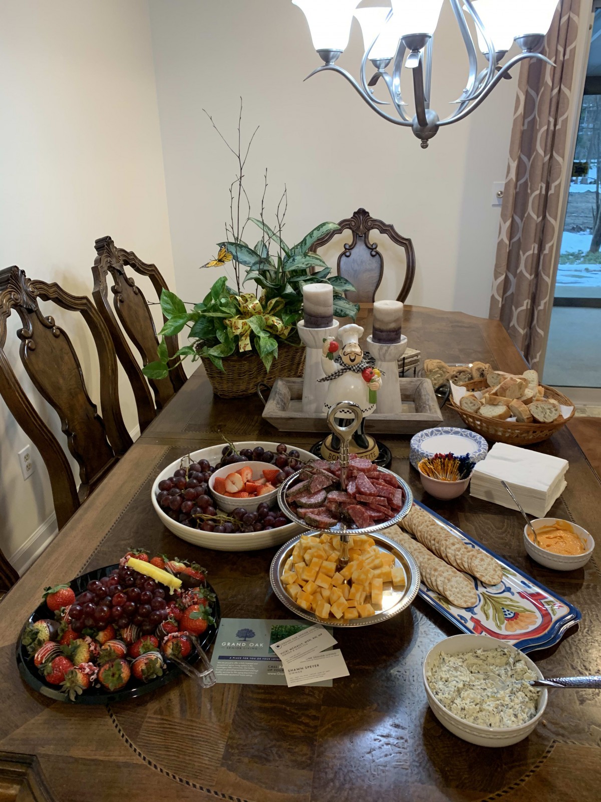 A beautifully set dining table with a variety of snacks and fruits, ready for guests.