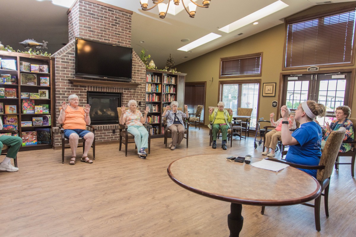 A group of seniors gathered in a comfortable seating area for a community meeting.