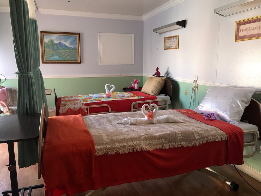 A cozy bedroom featuring two neatly arranged twin beds with decorative towel arrangements and art on the wall.
