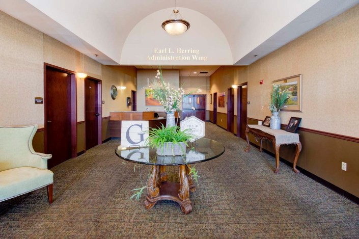 A welcoming reception area featuring elegant decor and a central table with greenery.