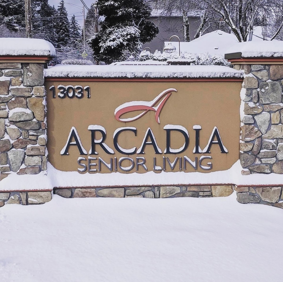 Arcadia Senior Living entrance sign covered in snow.