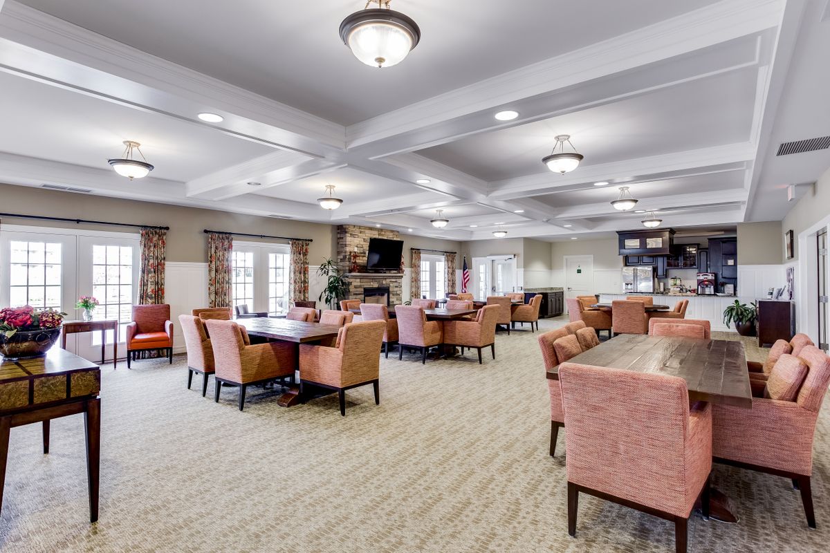 Spacious community lounge with multiple seating areas and modern lighting.