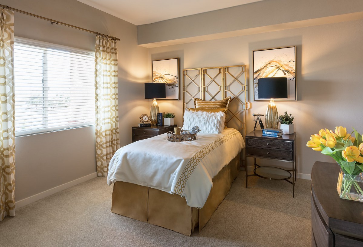 A well-decorated bedroom with a single bed, stylish lamps, and elegant decor.