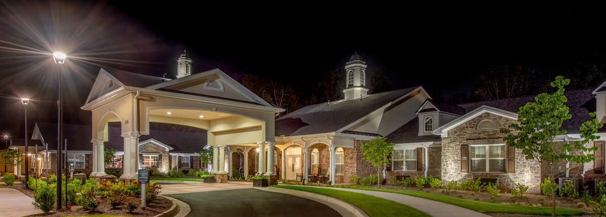 A well-lit building entrance at night, showcasing its architectural design.