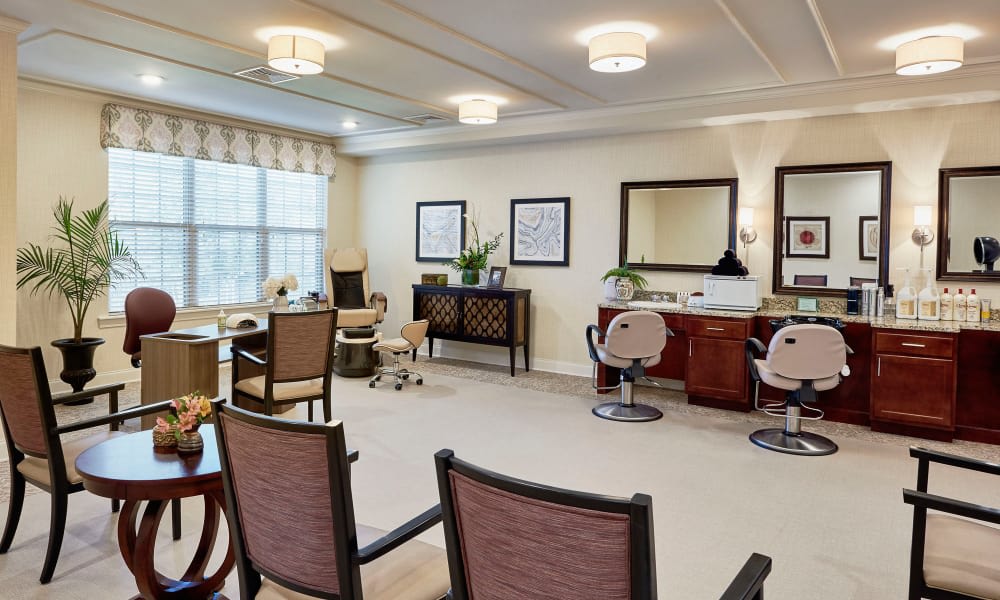 A well-appointed salon interior with chairs and mirrors, featuring elegant decor and lighting.