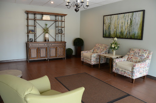 A cozy and elegant living room featuring comfortable seating, a stylish chandelier, and decorative elements.