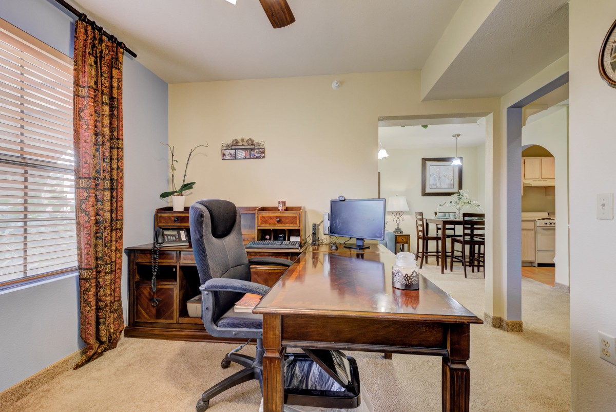 A cozy home office setup with a wooden desk and comfortable chair.