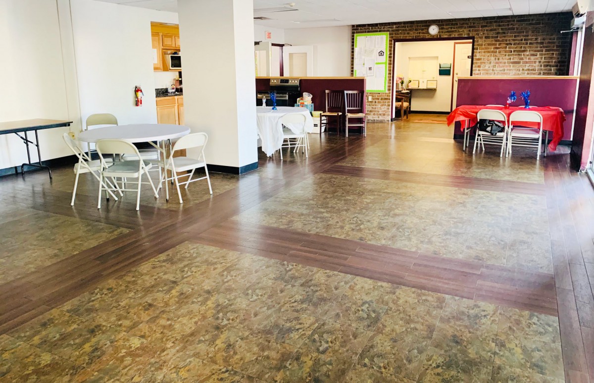 A spacious community center with seating areas and tables.